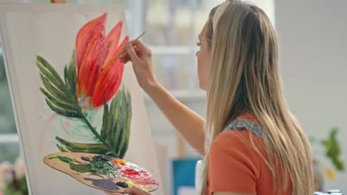 年轻的女画家在艺术工作室的画布上绘画。设计师在研讨会上通过艺术品表达自己。一位有创造力的女人独自在工