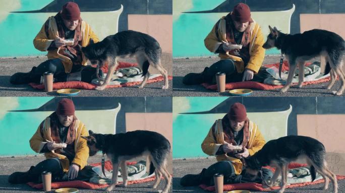 一个无家可归的人和他的狗在街上吃饭