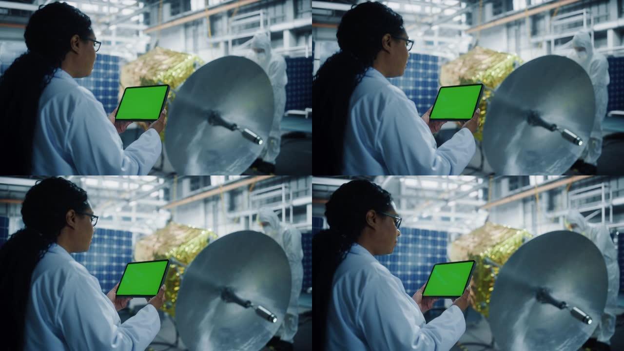 女工程师在进行卫星建设时使用绿屏平板电脑。航空航天局: 科学家为太空探索，观测任务组装和制造航天器