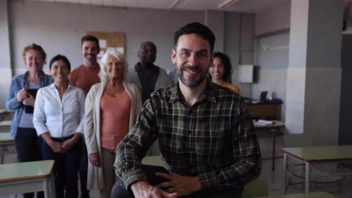 快乐的白人男老师在教室里，一群不同年龄和种族的学生都面带微笑