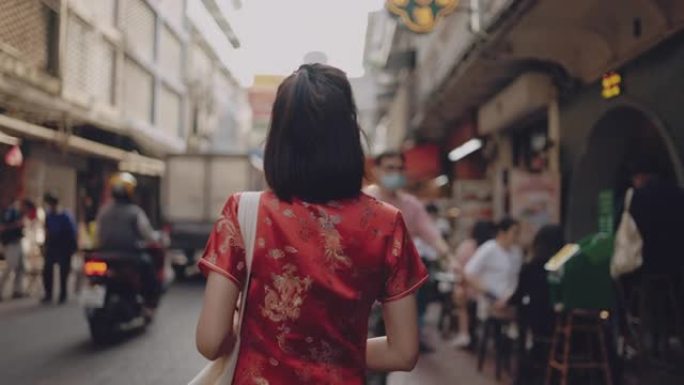 亚洲女性穿旗袍购物。