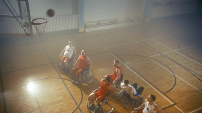 职业球场上的两队轮椅篮球比赛。截瘫球员比赛，射门，得分得分。残疾人的决心、技能。慢动作、高角度、航拍