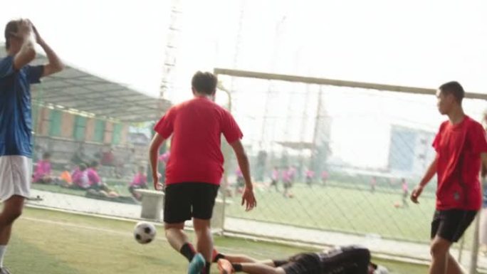 亚洲男子足球运动员与朋友一起打球。