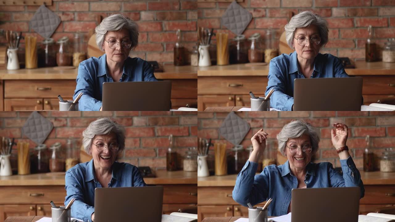 年长的女人使用笔记本电脑阅读好消息感到喜出望外