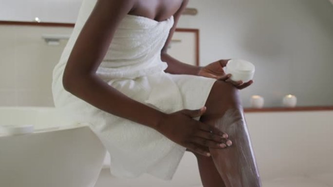 非裔美国迷人女性在浴室涂抹润唇膏