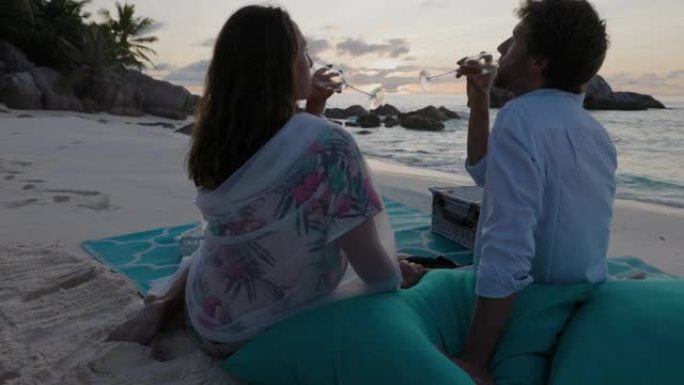 日落时分，浪漫的情侣在美丽的热带岛屿上享受日落