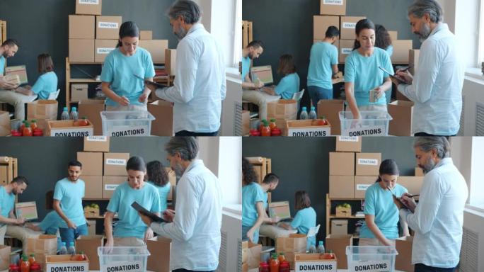 志愿者用容器包装食物，并与办公室的慈善公司经理交谈