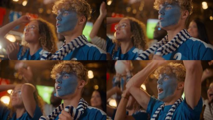 近距离观看一群支持足球迷，脸上涂着蓝色和白色的脸站在酒吧里，为他们的球队欢呼。举手大喊。朋友在进球后