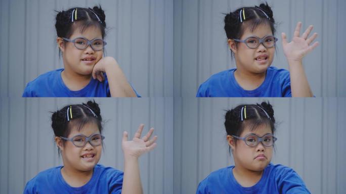 一个10岁的亚洲小女孩戴着眼镜，带着唐氏综合症的微笑站在教室里看着摄像机。残疾的肖像