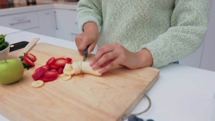 冰沙，早餐和一个女人在家里的厨房里切水果。健康，能量和营养，切香蕉以保持健康。减肥、健康和早上喝新鲜