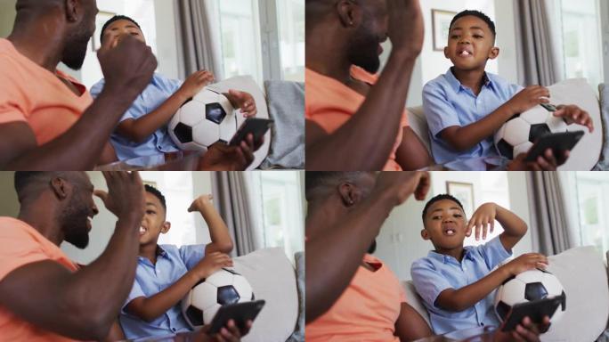 非裔美国人父子吃爆米花，用智能手机看足球比赛