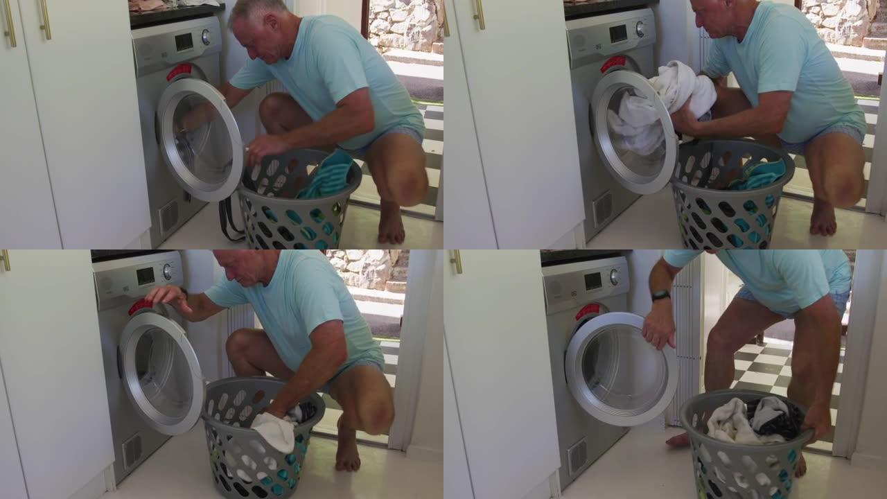 高加索高级男子在家中从洗衣机中脱衣服