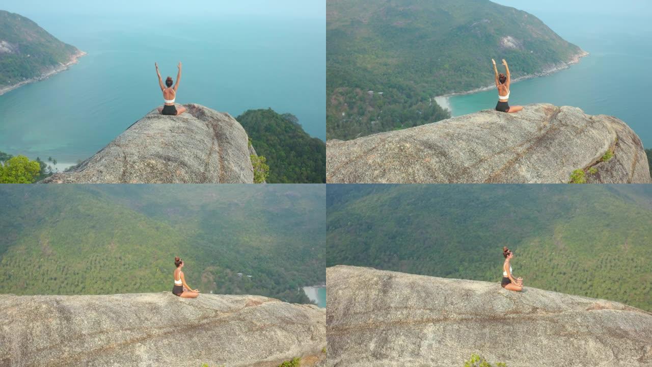 空中无人机视图和后视图，拉丁美洲和西班牙裔29岁的年轻女性在山顶海洋山顶上练习瑜伽的快乐。自然中的幸