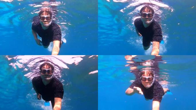 免费潜水员在清澈的海水和海水中的珊瑚礁中浮潜和自由潜水
