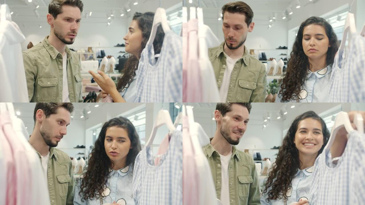 年轻夫妇在商店里讨论衣服，拿着衣服争吵，然后亲吻表达爱