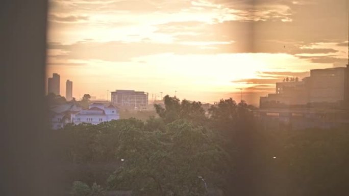 雨中夕阳透过窗户望向城市，夕阳在窗户上反射