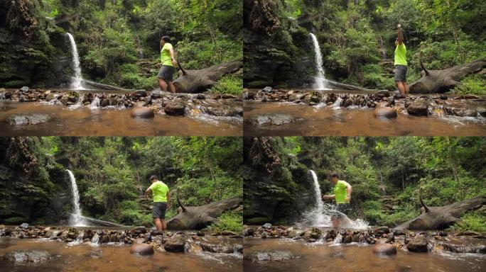 在雨林中进行越野跑的过程中，在瀑布上休息的男性越野跑运动员