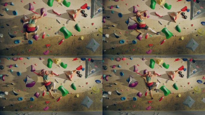 经验丰富的攀岩者在健身房的抱石墙上练习单人攀岩。男子在室内健身设施锻炼，做极限运动。运动员摔倒在安全