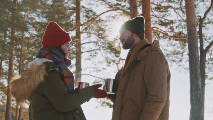 夫妇在冬天在森林里享受热茶