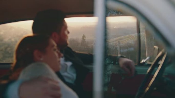 已婚夫妇坐在车内，欣赏日落时的景色