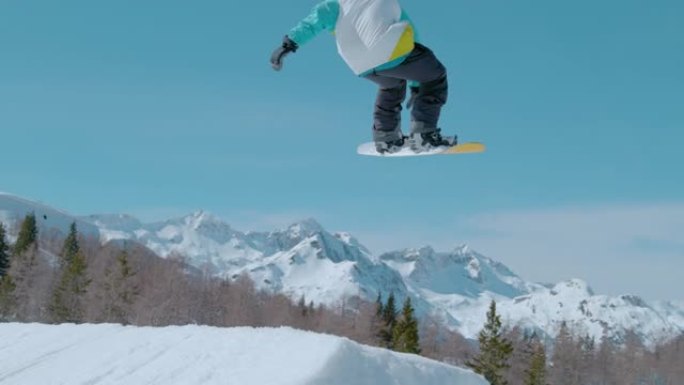 特写: 滑雪者在空中飞升，并进行旋转抓斗。