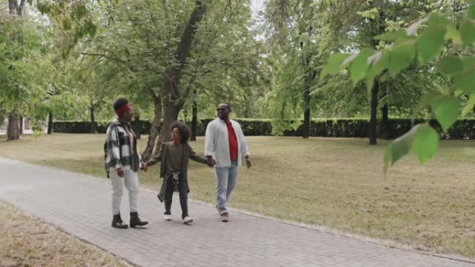 非裔美国人三口之家在公园散步
