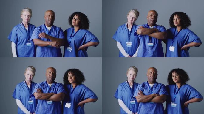 工作室肖像，三名外科团队成员穿着磨砂站在灰色背景下