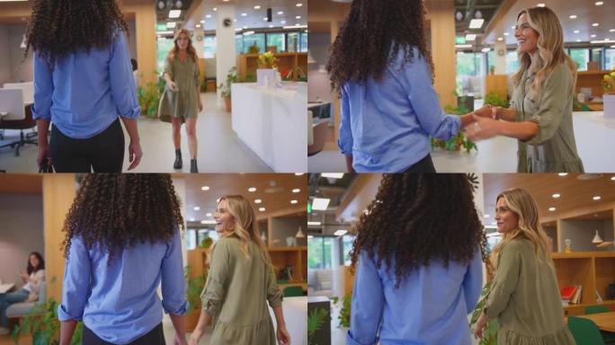 两名女商人在现代开放式办公室见面并握手-慢动作拍摄
