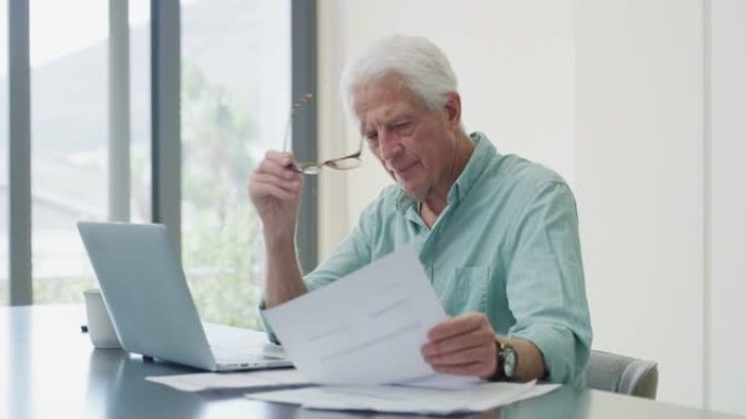 一个成熟的男人在使用笔记本电脑时阅读文书工作的4k视频片段