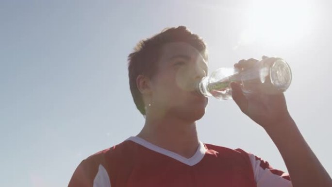 橄榄球运动员在晴天喝水