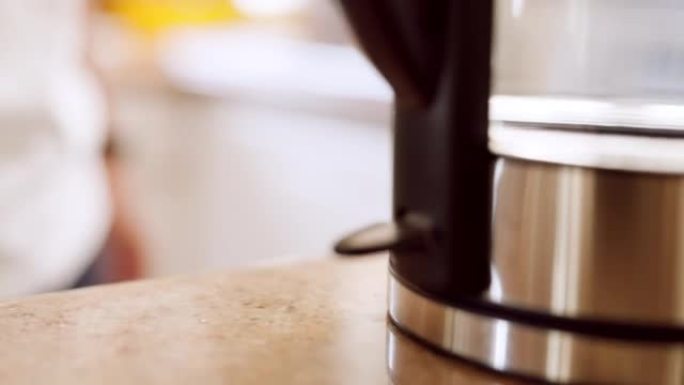 手打开水壶，厨房用具和热水器，用于在家中烹饪食物，茶和咖啡饮料。特写镜头在电水壶中加热液体，用于热，