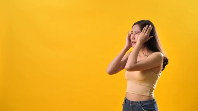亚洲妇女因孤立的黄色背景而头痛