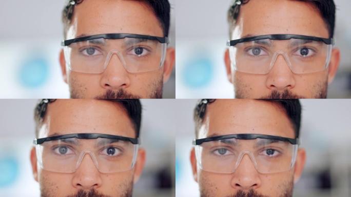 男性科学家眼睛和面部的特写镜头戴着安全眼镜或护目镜，以防止危险，有害物质的侵害。在实验室工作的孤立技