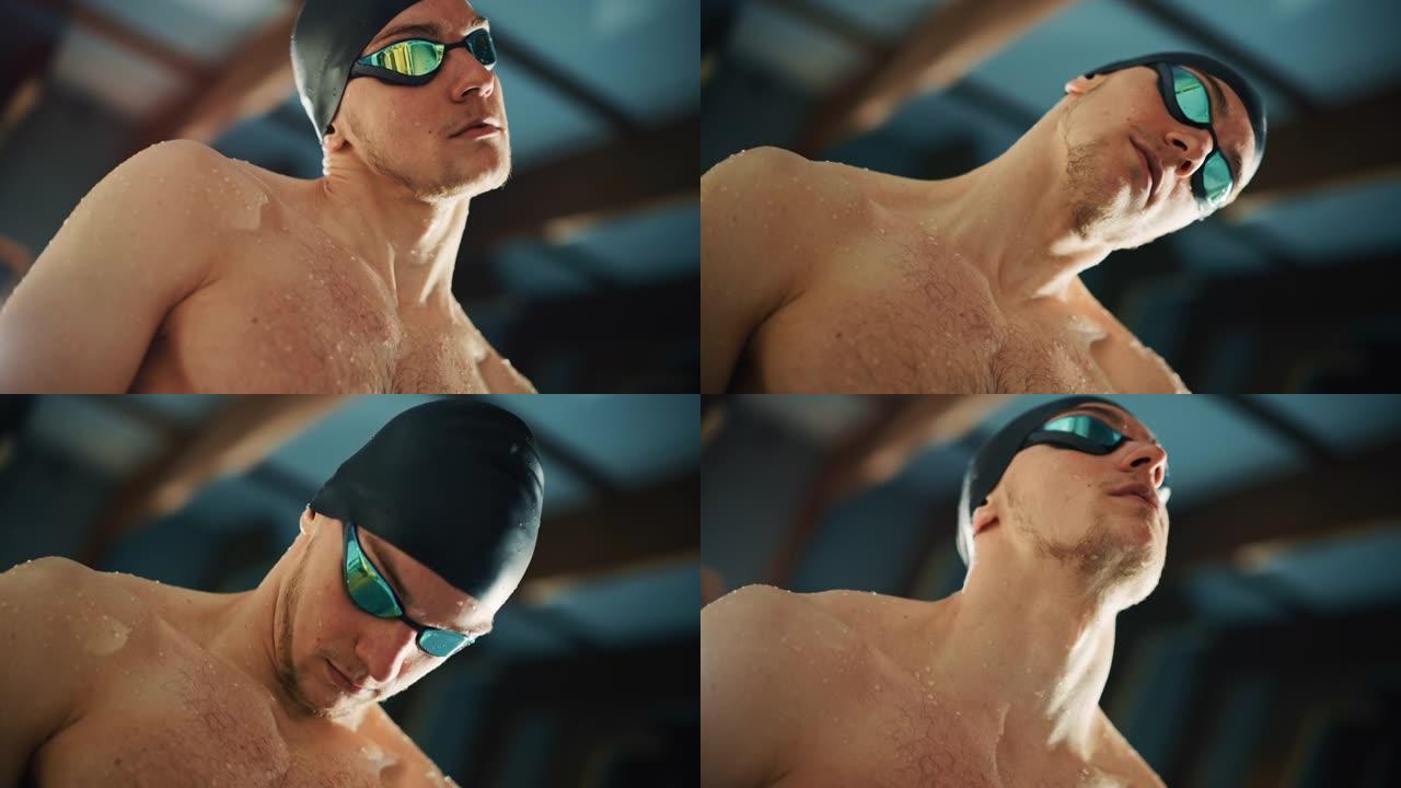 泳池里帅气的职业男游泳运动员，戴着帽子和眼镜，自信地看着镜头，准备夺冠。自信男人的电影肖像。低荷兰角