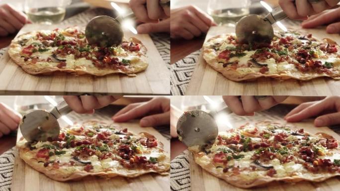 4k视频片段，一个无法识别的人使用比萨饼切割器切割比萨饼