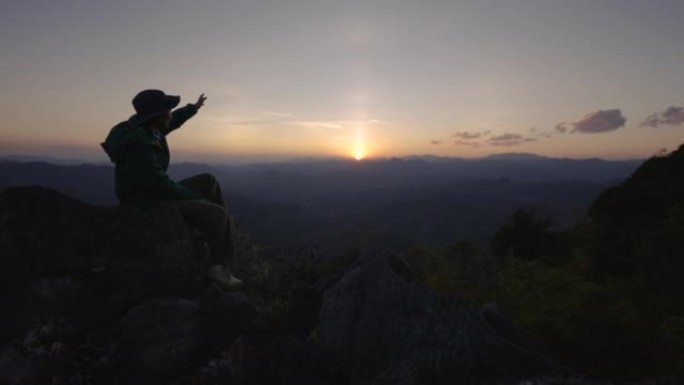 女人在山顶上徒步旅行，举手庆祝成功