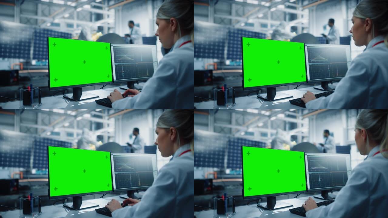 女工程师使用绿屏计算机分析卫星。航空航天局制造设施: 科学家开发，组装用于太空探索任务的航天器。超过