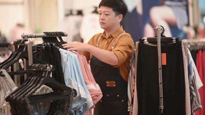 亚洲华人女精品店服装店老板工作挂衣