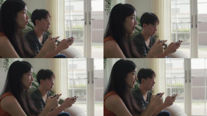 亚洲夫妇一起玩电子游戏很开心。