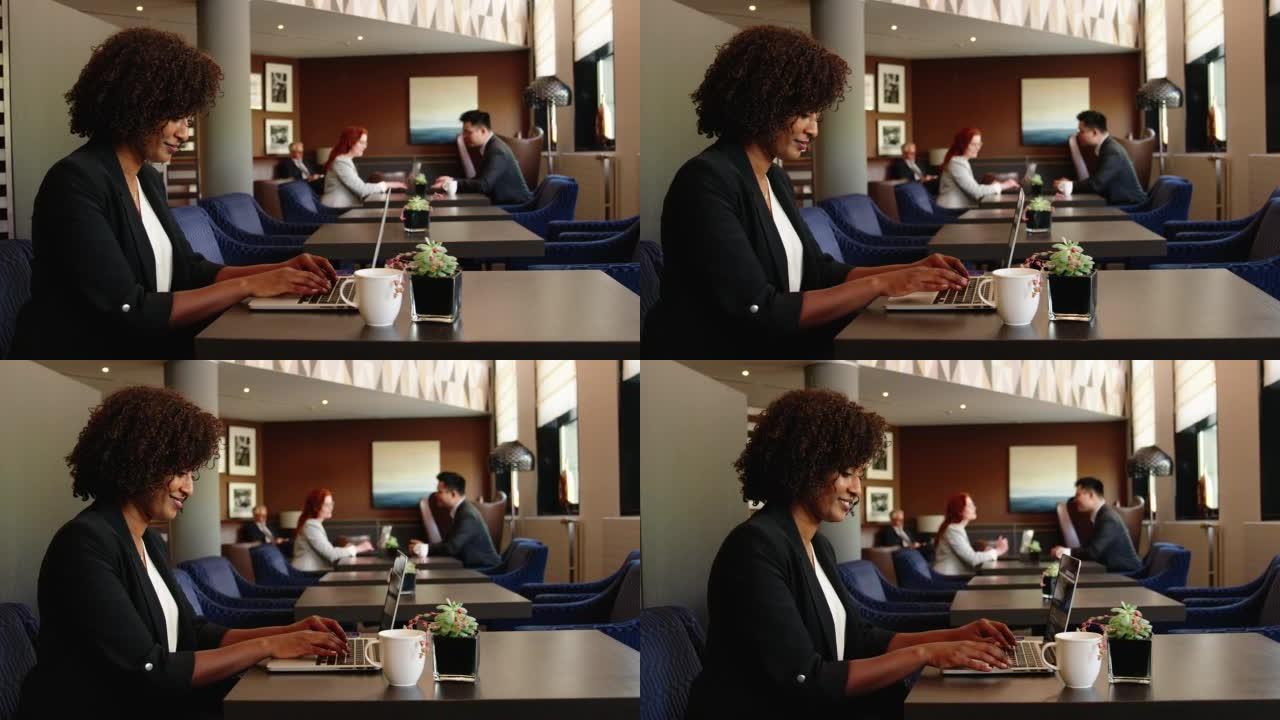 坐在商务休息室的非洲女商人在笔记本电脑上工作