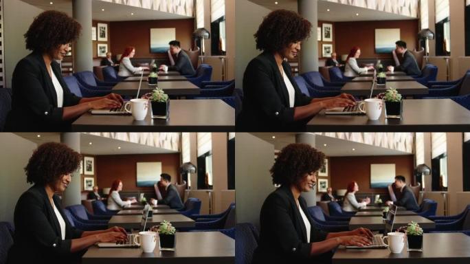 坐在商务休息室的非洲女商人在笔记本电脑上工作