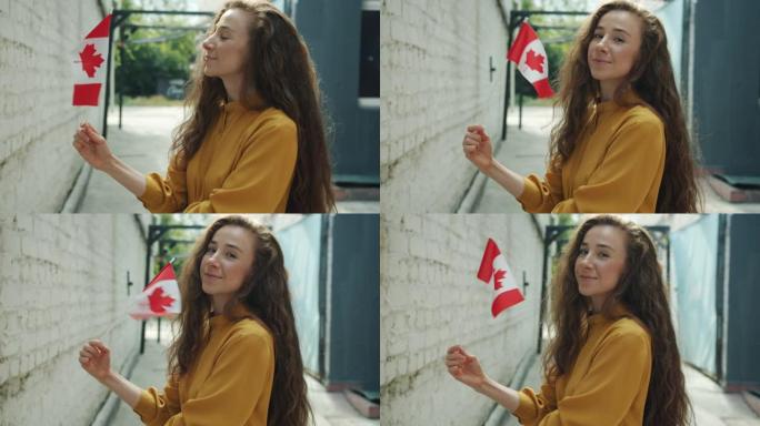 快乐的年轻女士的肖像挥舞着加拿大国旗，微笑着站在城市的户外