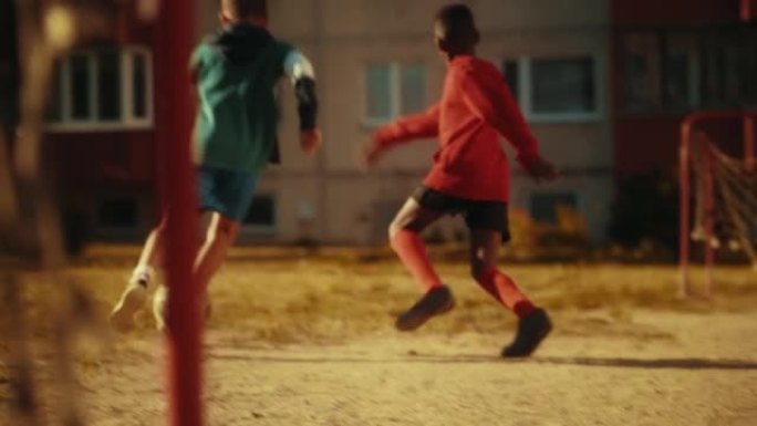 年轻的高加索男孩和不同的朋友一起踢足球。多民族的孩子在附近享受足球比赛。与队友一起庆祝进球的球员。