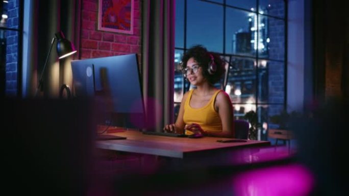 晚上，年轻的多种族女性在时尚的阁楼公寓里用电脑聊天。快乐的创意女性在家工作，与客户支持或家人和朋友交