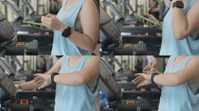 准备在跑步机上跑步的运动型女性准备耳机，智能手表和智能手机，特写镜头