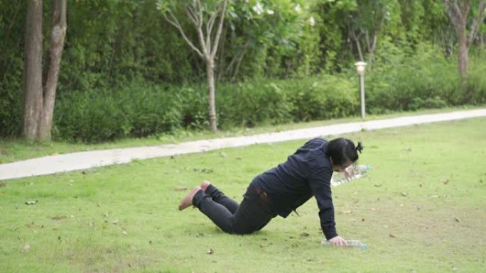 亚洲男子试图在新型冠状病毒肺炎期间在家庭花园或公园用水瓶锻炼