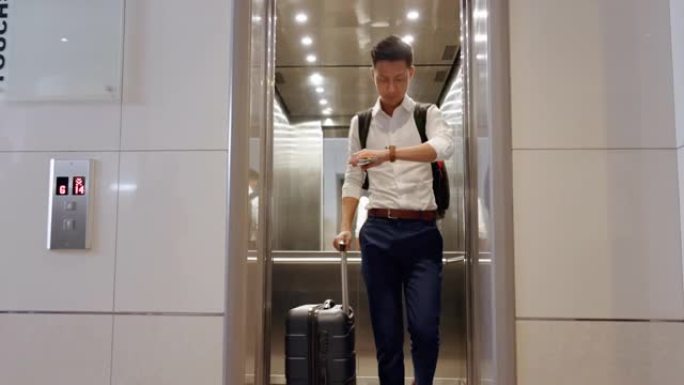 电梯，旅行和在机场与一名亚洲商人一起观看，检查他的航班起飞时间。门、地板和迟到，一名男性员工在旅行时