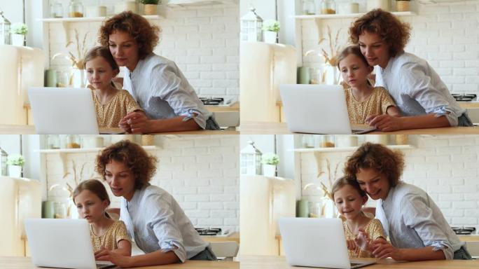 有爱心的母亲使用笔记本电脑帮助女儿完成学业