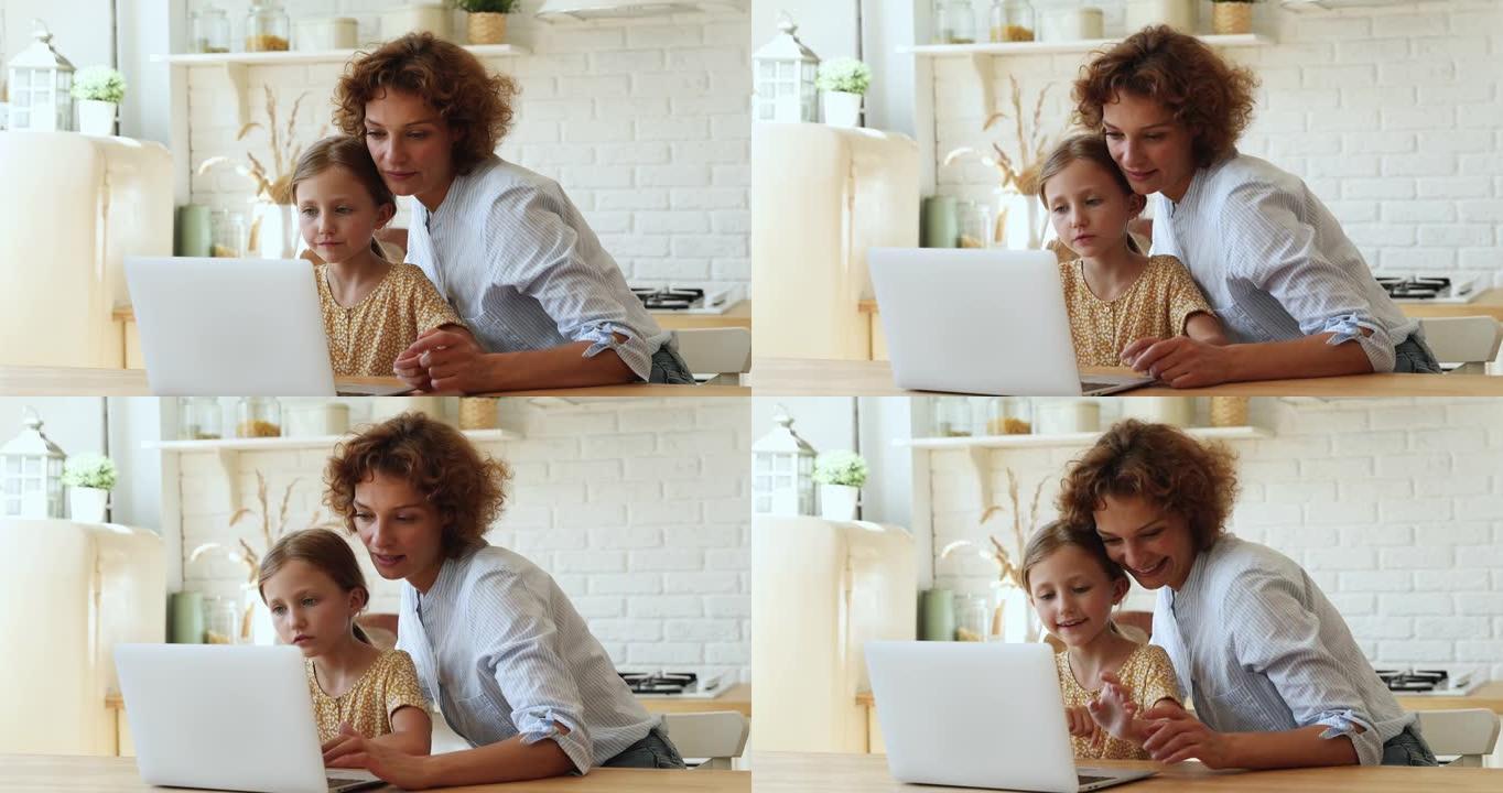 有爱心的母亲使用笔记本电脑帮助女儿完成学业