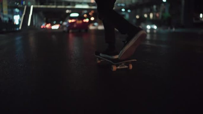 一个男人晚上在街上玩滑板
